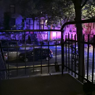 Street from the 2nd floor landing illuminated with red and blue lights